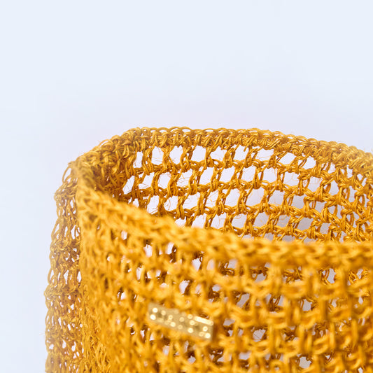 Close-up Aura Solar Ember yellow crossbody woven bag handcrafted from natural fique fiber, designed by Oda Nova to honor feminine strength and Colombian craftsmanship.