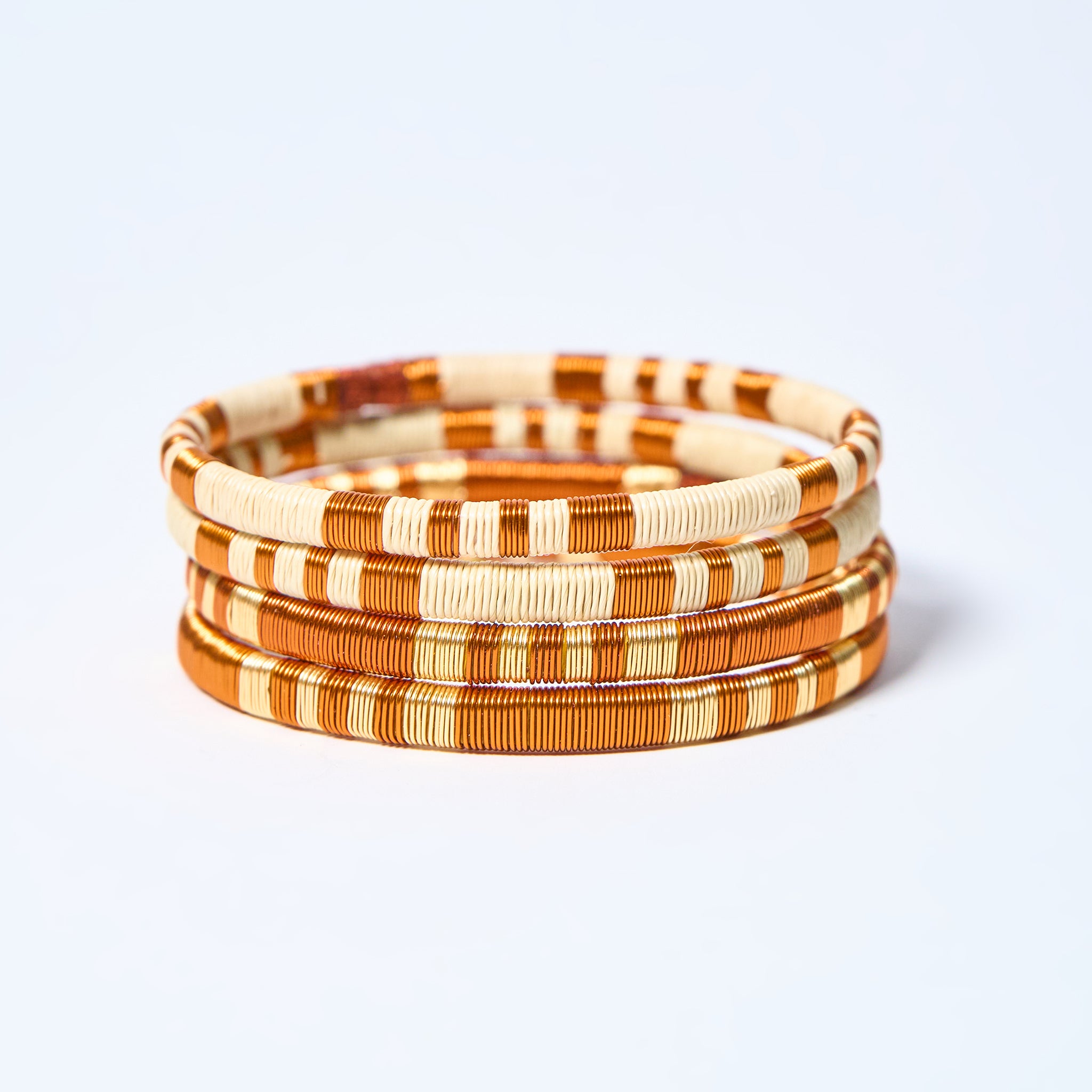 Set of four handmade striped bracelets in copper and cream