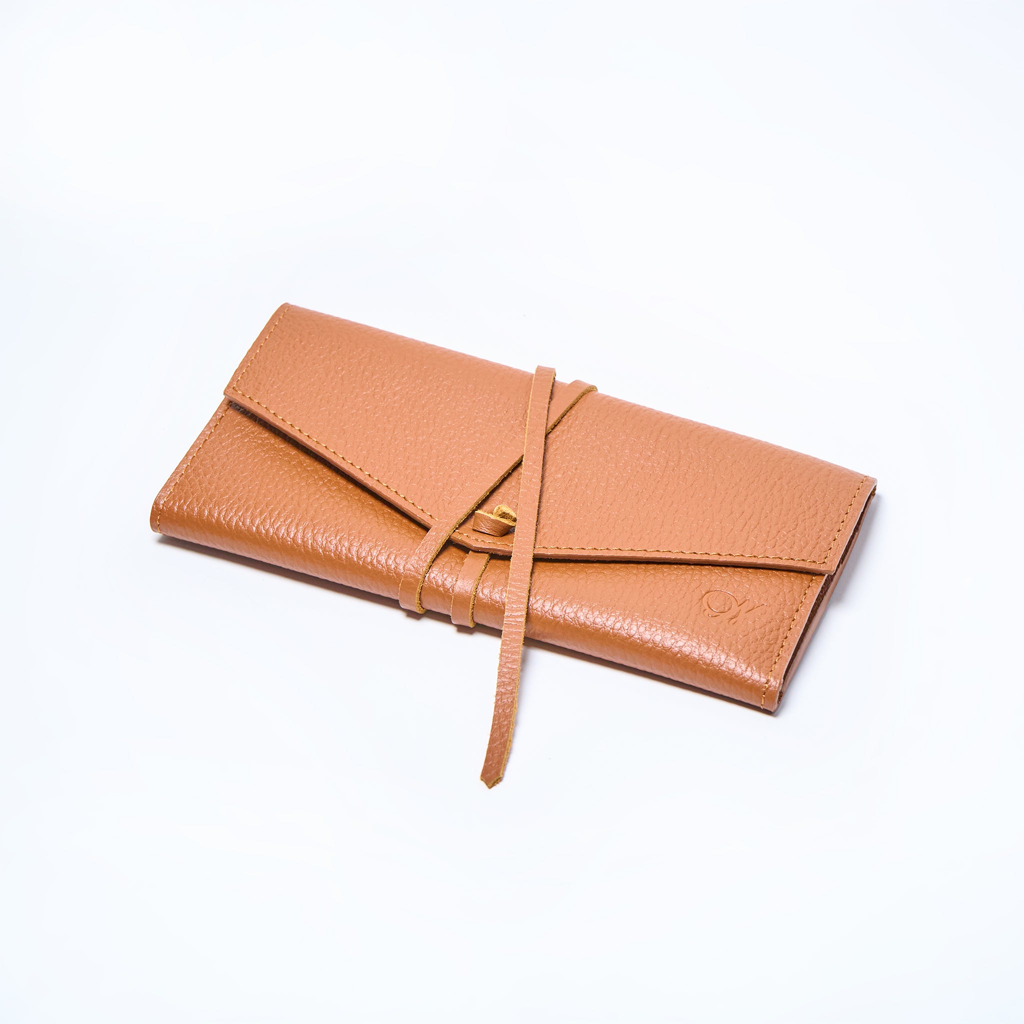 Honey brown leather wallet closed on a light gray background. handcrafted by Oda Nova with space for 8 cards and bills