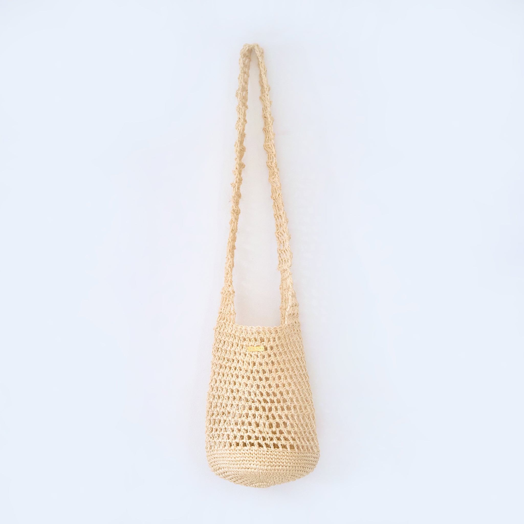 Aura cream crossbody woven bag handcrafted from natural fique fiber, designed by Oda Nova to honor feminine strength and Colombian craftsmanship.
