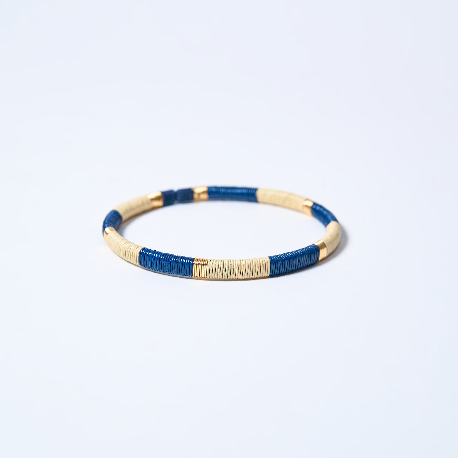 Handmade striped bracelet with blue, cream and gold pattern