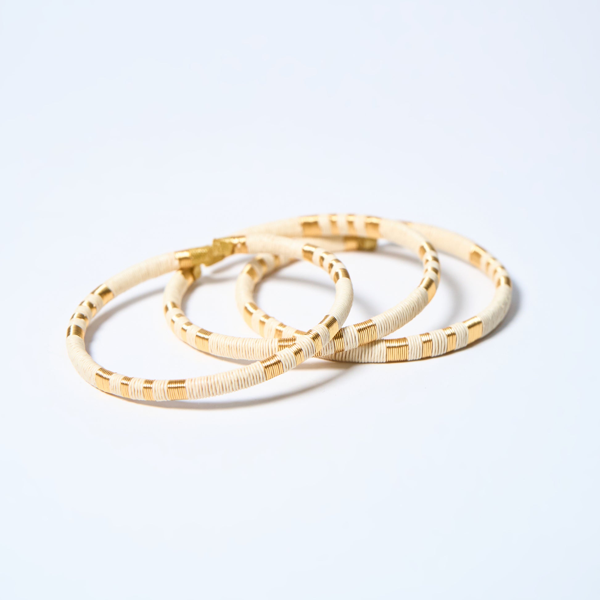 Set of  handmade striped bracelets in cream and gold