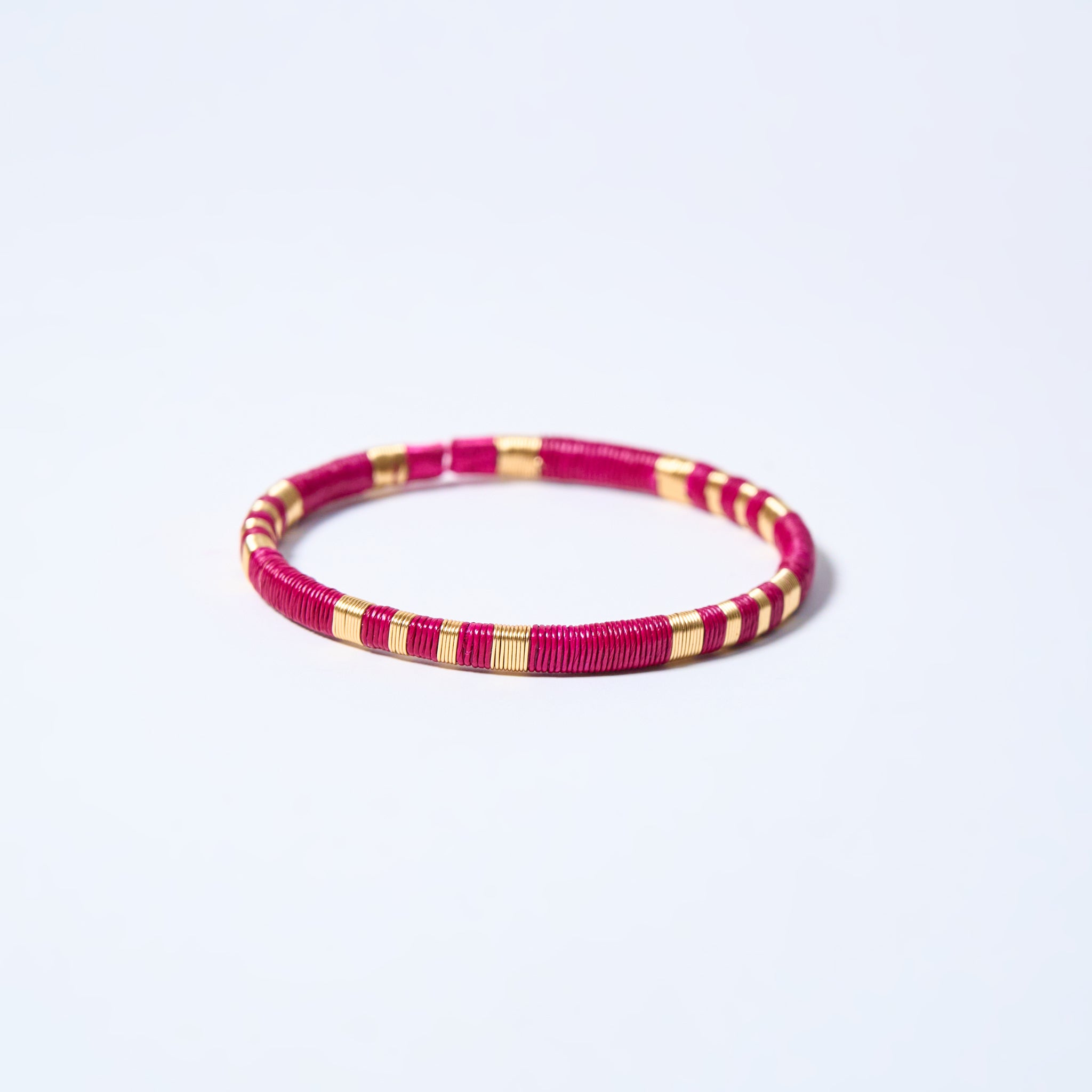 Handmade striped bracelet with fuchsia and gold pattern