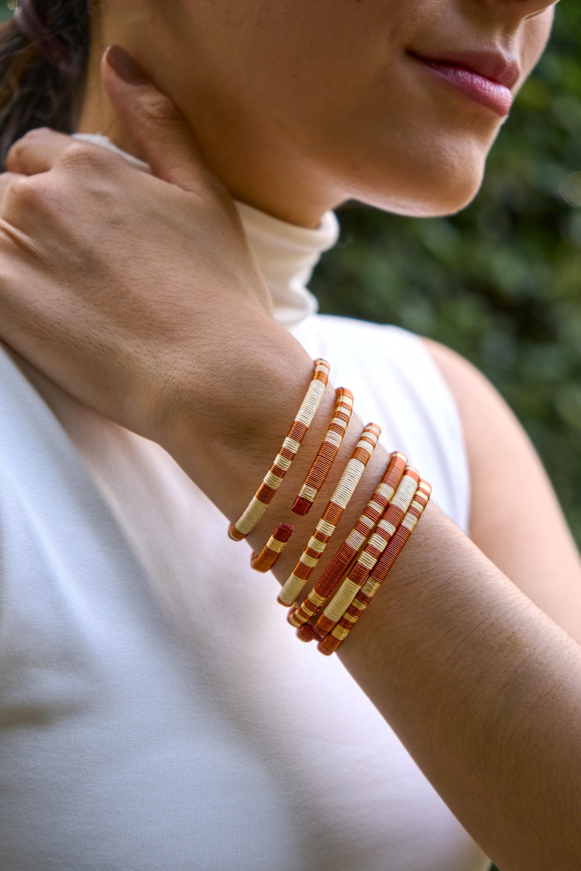 Close-up of a person wearing multiple handmade bracelets on their wrist 