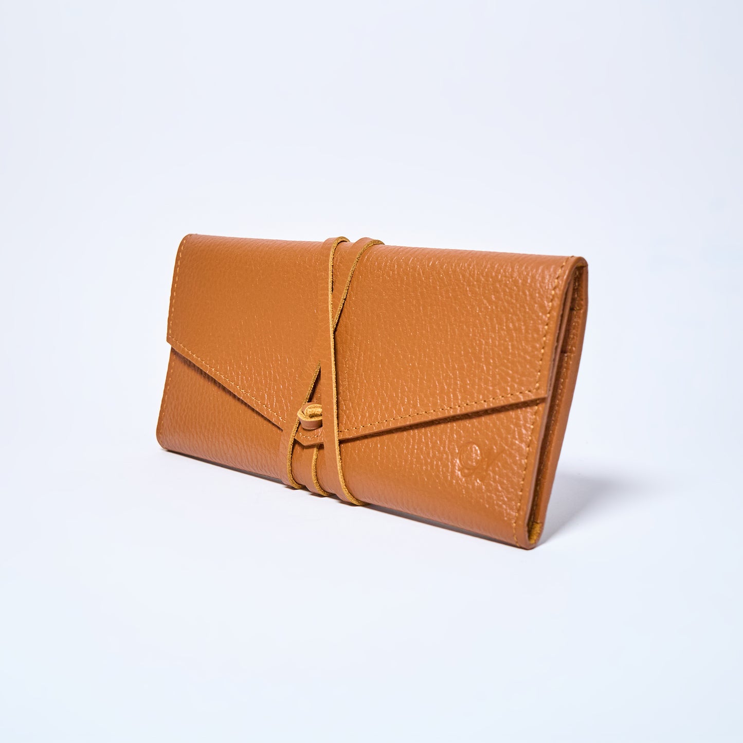 Honey brown leather wallet on a light gray background. handcrafted by Oda Nova with space for 8 cards and bills