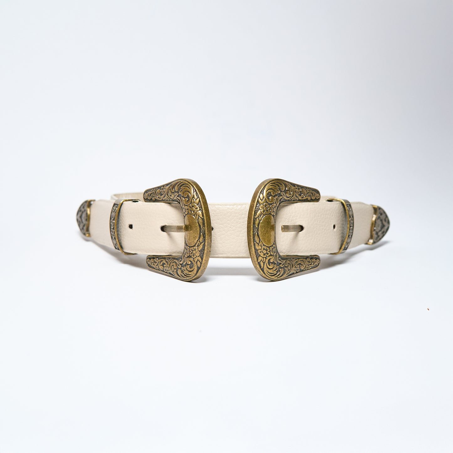 Pair of white leather belts with gold buckles on a light gray background
