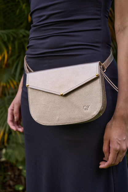 Model wearing Lyra leather crossbody bag in the waist with a blurred natural background